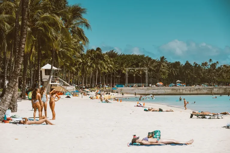 Palm trees and beachgoers along Waikīkī Beach in Honolulu
